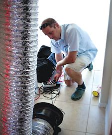 A BPI-certified professional performs a duct leakage test.
