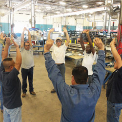 TDIndustriesâ€™ prefabrication shop crew participates in stretching exercises before they begin their shift.