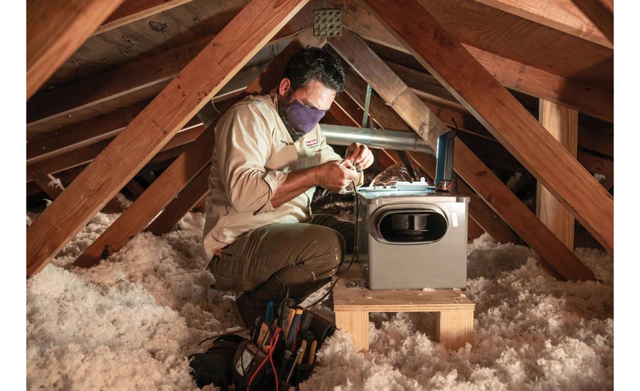 A tech installs an Aprilaire unit in an attic.