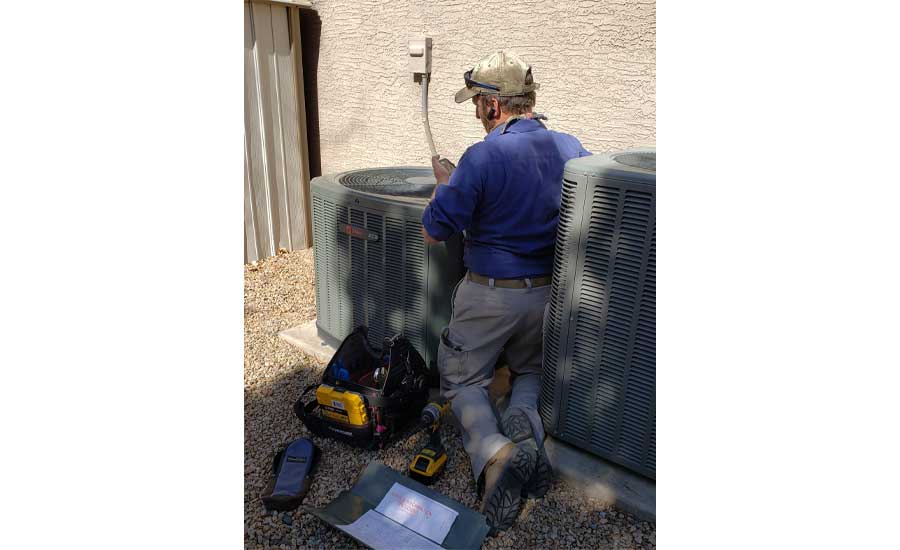 Technician servicing air conditioning equipment.