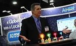 Rick Wilcox performs magic and card tricks for a crowd at the Air-Conditioning, Heating, and Refrigeration Institute (AHRI) booth. - The ACHR News