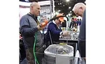 Attendees lined up to try out SpeedClean’s CoilShot condenser cleaner tool. - The ACHR News