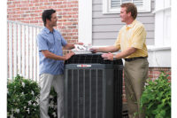 contractor and homeowner standing next to a/c unit