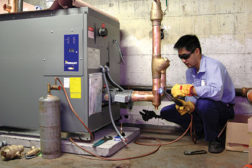 An ACA Denver Boiler technician completes connections for a Laars Pennant boiler/volume water heater in an apartment building in downtown Denver.