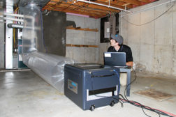 An Aeroseal contractor works on sealing the ductwork inside a home. The aerosolized vapor travels throughout the ductwork, automatically sealing leaks from the inside. (Photo courtesy of Aeroseal)