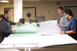 Left to right, Nick Jackson, Kevin Blankenmeier, and Anthony Campbell go over blueprints at Jackson & BlancÃ¢??s headquarters in San Diego.