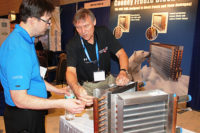 Sheldon Petrie, project manager, Mafna Air Technologies Inc., listens in as Rick Kobylinski of Cooney Coil & Energy Inc., describes how his companyâ??s freeze block coil product operates.
