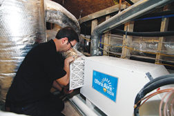 Matt Risinger, owner of Risinger Homes in Austin, Texas, works on a Ultra-Aire XT105 dehumidifier. As buildings get tighter, the need for dehumidification is going to rise, said Nikki Krueger of Ultra-Aire.