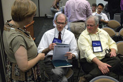 Kenneth Schultz, center, of Ingersoll Rand, consults notes while in conversation following his presentation at Purdue University on low-GWP refrigerants in elevated ambient conditions.