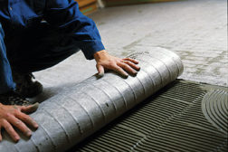 A professional tile setter installs a Nuheat Mat onto the subfloor. A certified electrician will be brought in to connect the wiring system.