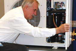 Keith Pohlman, president, All Temp Refrigeration Inc., examines the schematic of a demonstration compressor.