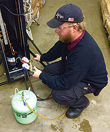 Ryan Brown, a technician for AirTight Mechanical in Charlotte, North Carolina, services a portable R-22 system used for data center hot spots. (Photo courtesy of AirTight Mechanical)