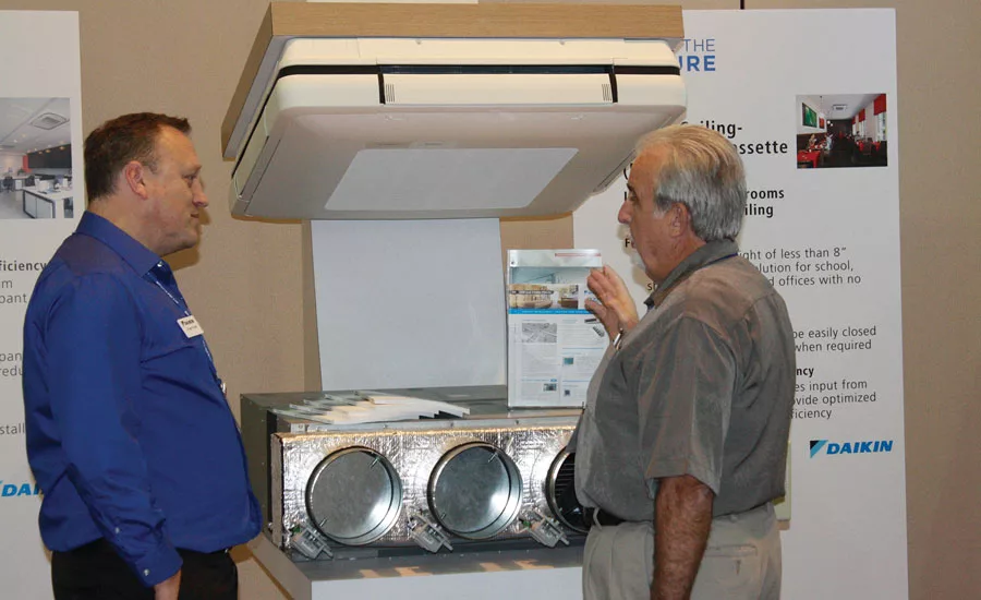 Robert Powell (left), VRV application engineering manager, Daikin North America, explains the benefits of Daikin's VRV products to a sales meeting attendee.