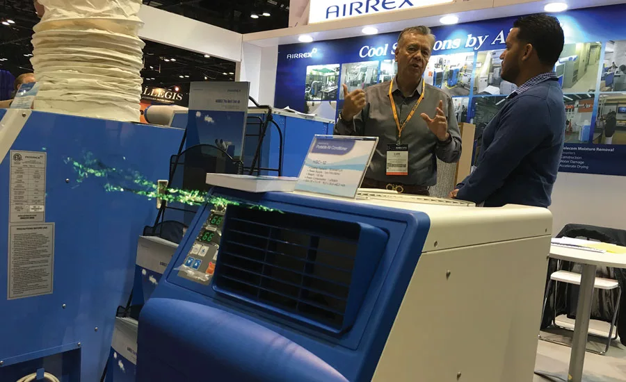 Luis Cheas (left), a sales manager for Airrex USA LLC, talks with an AHR Expo attendee about the company’s portable cooling and heating solutions.