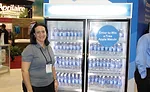 Stefanie Kopchick, Chemours’ North America marketing manager for refrigerants, poses with a glass-door merchandiser running on the company’s Opteon refrigerant.