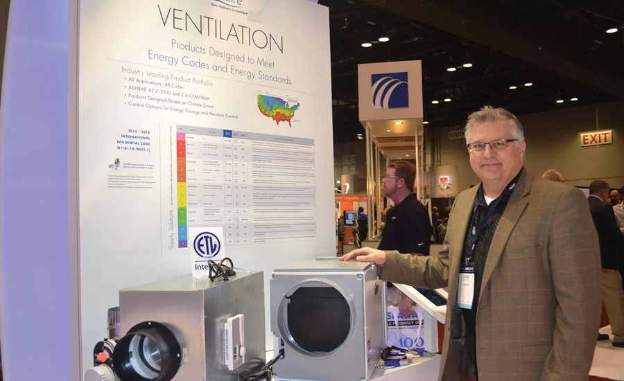 Chris Chase, product marketing manager, air cleaners, thermostats and zone comfort controls, Aprilaire, stands next to the manufacturer’s new Model 8191 and 8192 whole-home ventilators with dehumidification.
