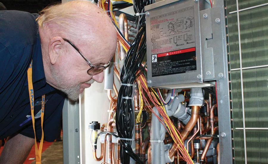 J.F. Townsend, Region 14 director, Refrigeration Service Engineer Society (RSES) in Downey, California, takes a close look at the inner workings of a new Daikin unit.