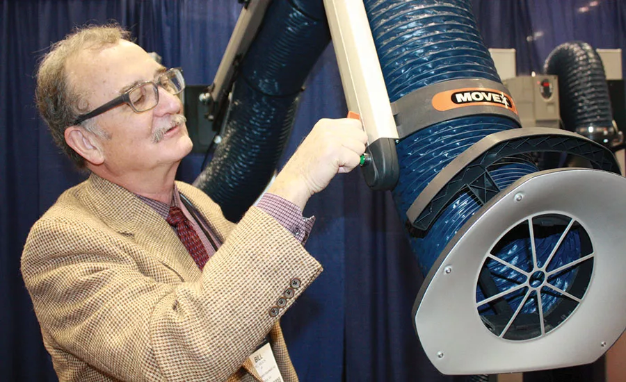 Bill Wilson, a rep with Capital Energy Equipment Inc. in Vienna, Virginia, tests  the flexibility of one of Movex’s Fume  Extractor Arms.