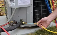 TO SEAL OR NOT TO SEAL? A technician adds a refrigerant sealant to the suction side of a residential air conditioning unit. Photo courtesy of Nu-Calgon