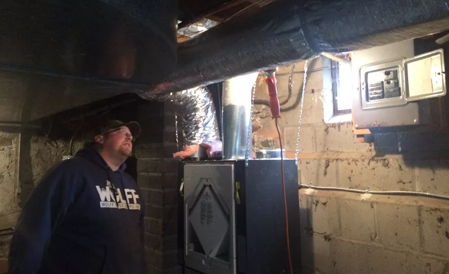 Jason Wichert of Burton Sheet Metal Inc. in Burton, Ohio, performs an inspection of the ductwork in a home. photo courtesy of Nate Adams, Energy Smart Home Performance