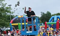 REIGNING AND RAINING Dan Jape, CEO of Reliable Heating & Air, Woodstock, Georgia,“makes it rain” dollars at the company’s summer employee party.