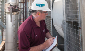 A building engineer examines an LST-style centrifugal cooling tower during a routine maintenance checkup. PHOTO COURTESY OF EVAPCO INC.