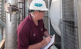 A building engineer examines an LST-style centrifugal cooling tower during a routine maintenance checkup. PHOTO COURTESY OF EVAPCO INC.