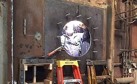 workers weld on a burner plate