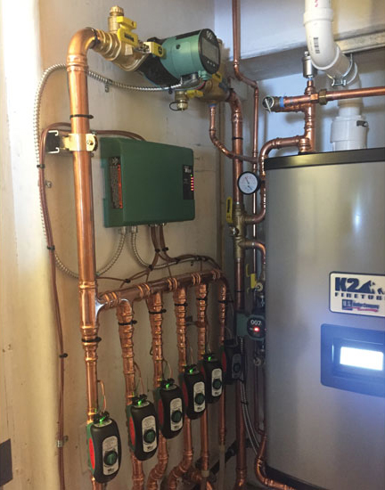 This high-efficiency gas boiler replacement shows near-boiler piping, a main Taco ECM circulator, and a 007e zone circulator with Zone Sentry zone valves for each of six zones. - ACHR
