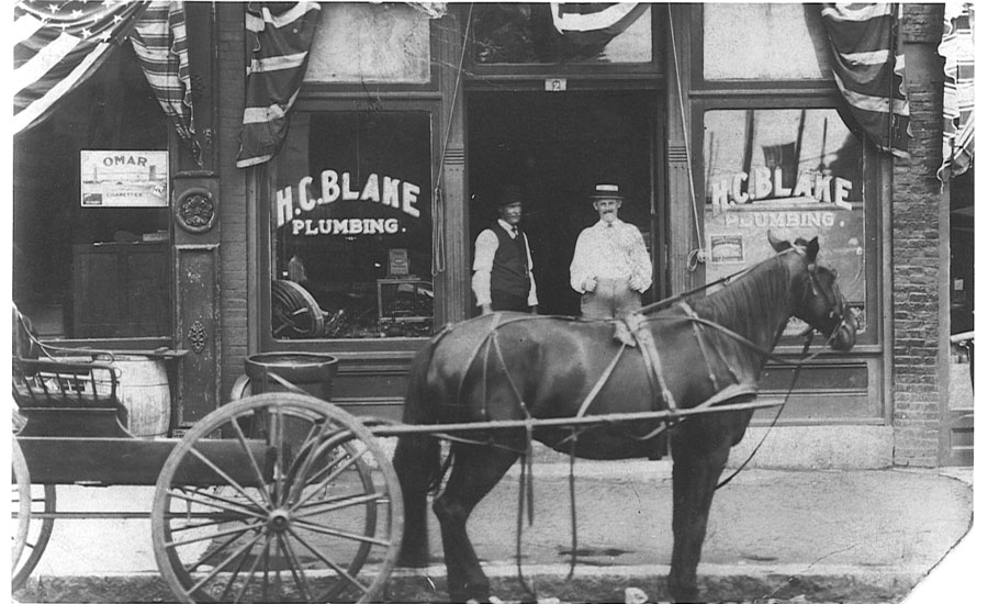 a photo of a horse and buggy outside a storefront with the words “H.C. BLAKE PLUMBING” - ACHR