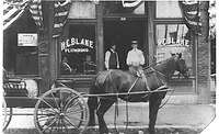 a photo of a horse and buggy outside a storefront with the words “H.C. BLAKE PLUMBING” - ACHR