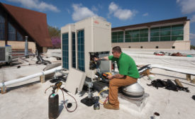 Eco-Green Air installers charge two new VRF units on a church roof. - ACHR