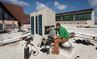 Eco-Green Eco-Green Air installers charge two new VRF units on a church roof. - ACHR