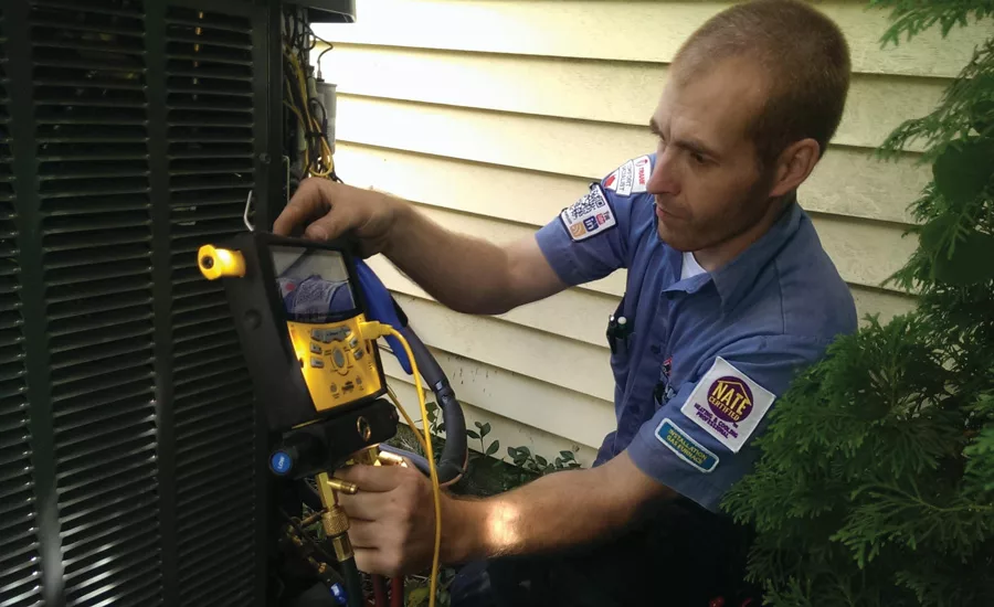 Bryan Jones, an installer at Fire and Ice Heating and Air Conditioning, Columbus, Ohio, ensures the charge is correct. - ACHR