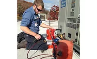 Nick Briggs, service technician, Pleune Service Co., Grand Rapids, Michigan, works on a unit. When it comes to service work, the company uses overtime as a tool to dampen demand during peak times - The NEWS - ACHR