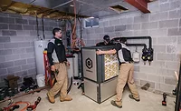 Vertex-Mechanical-Q-Energy-Heat-Pump-ACHR-News.jpg Vertex mechanical technicians move the 4-ton Q Energy ground source heat pump into place during a retrofit. - The ACHR News