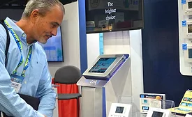 A visitor at the Braeburn booth stops to admire the simplicity of the company’s smart thermostat offerings. - The ACHR News