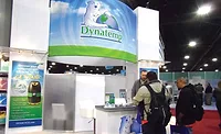 Dynatemp’s Will Gresham (behind counter) talks to several expo attendees about R-421A, which is a long-term replacement refrigerant for R-22. - The ACHR News