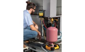 Technician inspecting outside condensing unit. - The ACHR News