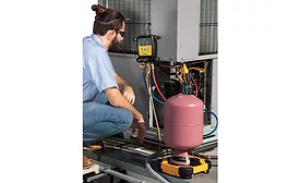 Technician inspecting outside condensing unit. - The ACHR News