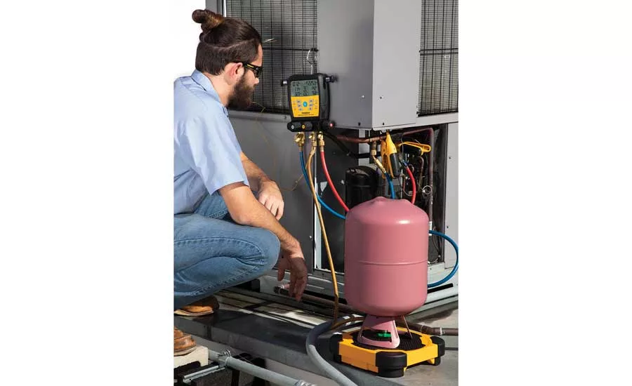 Technician inspecting outside condensing unit. - The ACHR News
