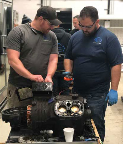 Technicians break down and troubleshoot a compressor failure at Climate Pros University. - The ACHR News