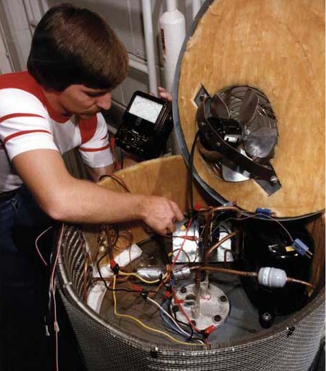 Technician Phil Childes uses a multimeter to check connections in a heat pump water heater.