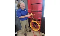 Conducting a blower door test to determine leakage.