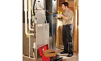A technician installs an Emerson Sensi Predict.