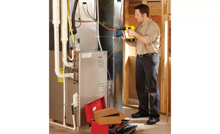 A technician installs an Emerson Sensi Predict.