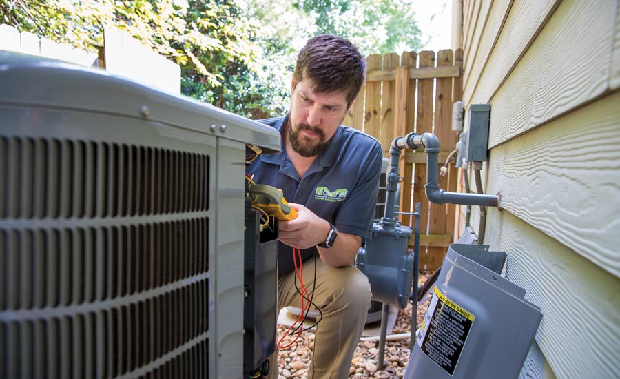 A Moncrief employee working on an air conditioner.