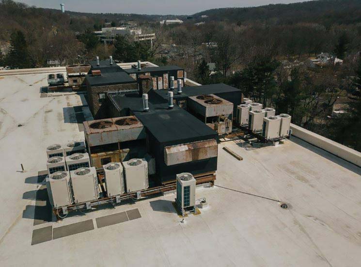 The complete VRF systems installed in phase one can be seen on the right, with the original system still in place on the left, during the Tarrytown office building’s HVAC system retrofit.