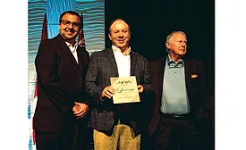 ACHR NEWS editorial director Kyle Gargaro (at left) and Ron Smith (at right) present The ACHR NEWS’ Ron Smith Leadership Award to Jim Batson, owner and CEO of H.C. Blake Co.