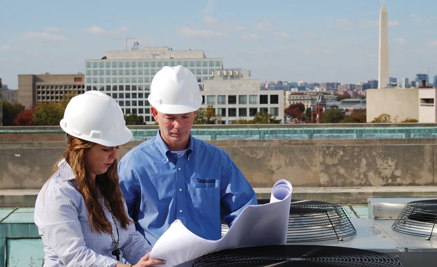  Trademasters president and CEO Dave Kyle reviews some plans for a rooftop project with coworker Katie Allen.
